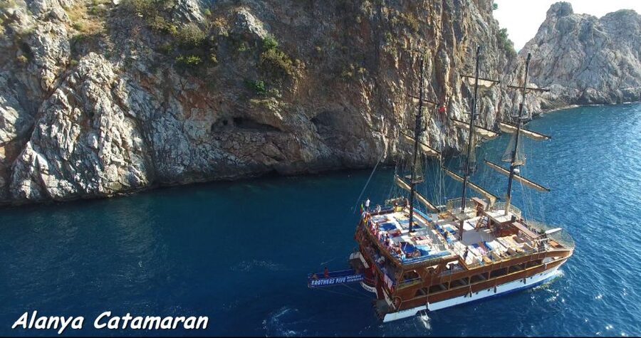 Alanya: Catamaran Boat Trip with Sunbathing and Swimming - Leaving Alanya Harbor near the Red Tower